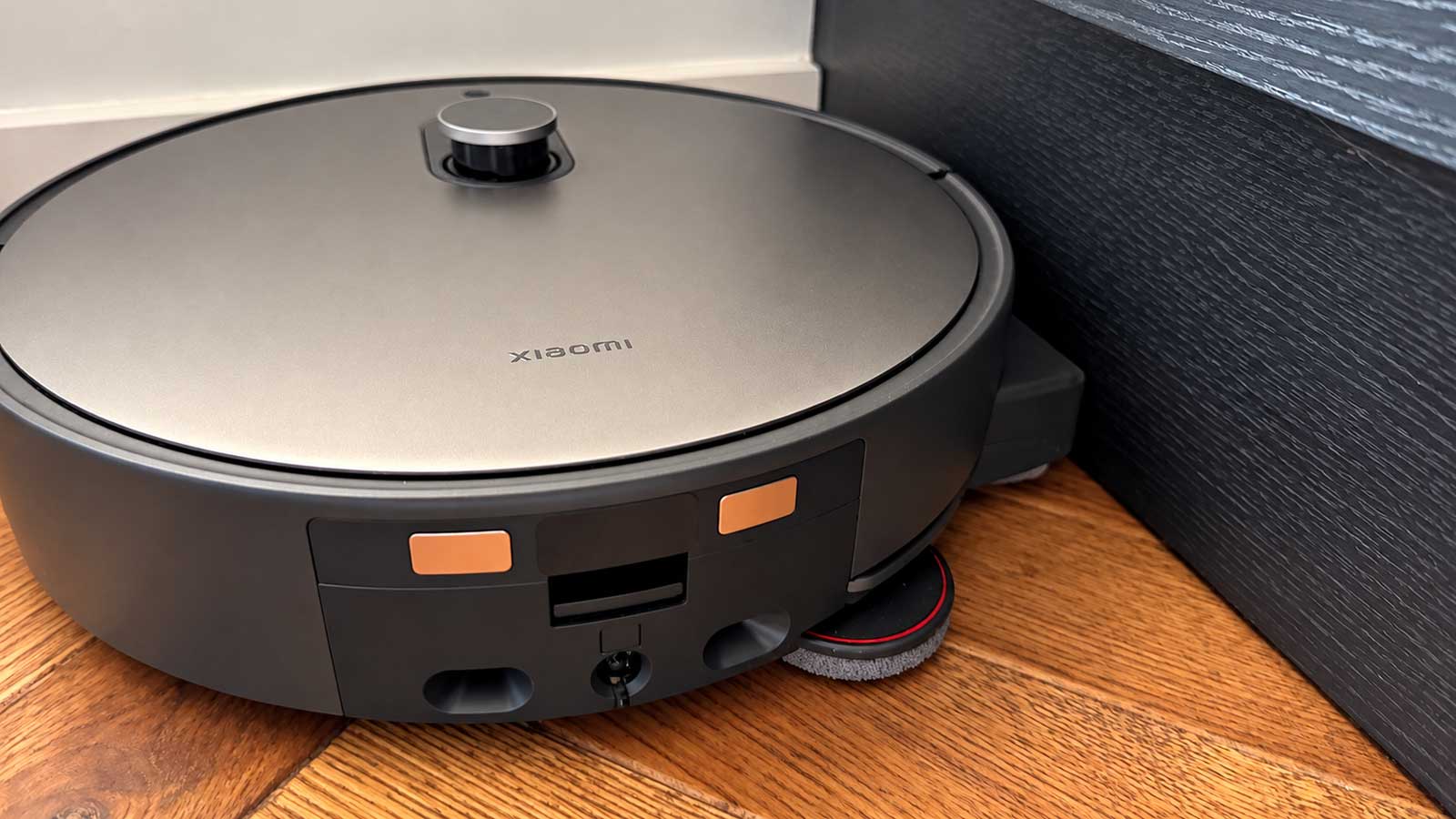 Xiaomi Robot Vacuum 6 Max lavant le sol le long d’une plinthe avec son rouleau serpillière décalé
