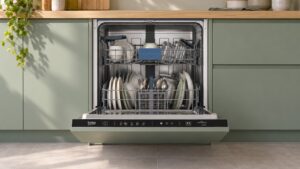 Lave-vaisselle tout intégrable Beko BLVI84F installé dans une cuisine, porte ouverte sur ses paniers