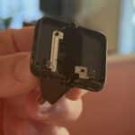 Main tenant la partie d’un chargeur USB-C cassé restée dans la prise : les broches dépassent dessous et deux lamelles de métal sont à nu sur le dessus