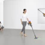 Dyson V12 Detect Slim Absolute utilisé au sol, sous un meuble et en aspirateur à main dans une pièce claire