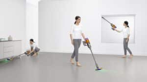 Dyson V12 Detect Slim Absolute utilisé au sol, sous un meuble et en aspirateur à main dans une pièce claire