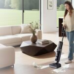 Aspirateur laveur Tineco Floor One i6 Stretch passé sur le parquet d’un séjour, un chien à côté