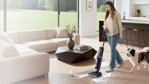 Aspirateur laveur Tineco Floor One i6 Stretch passé sur le parquet d’un séjour, un chien à côté